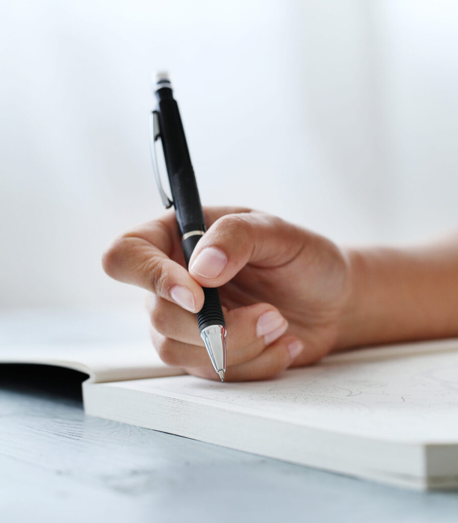 woman writing on a notepad with a pen