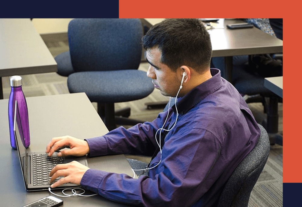 Person sitting in front of a computer using assistive devices to work,.