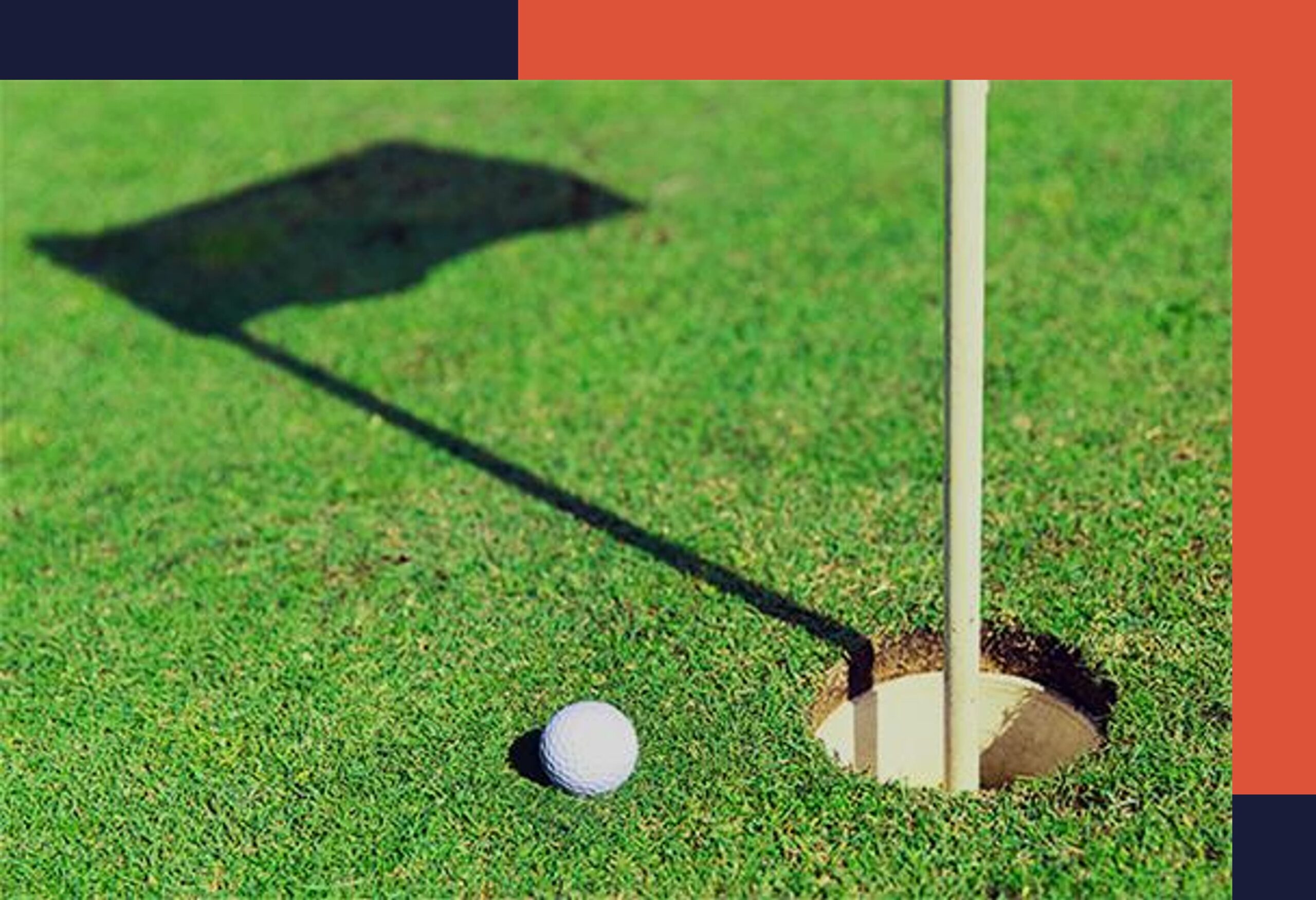 golf ball on the green next to hole with a shadow of the flag
